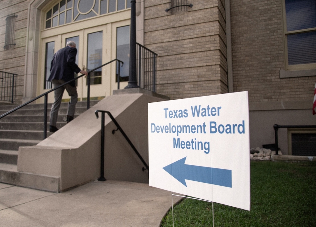 texas-water-development-board-meeting-entrance Man entering building for Texas Water Development Board meeting with directional sign in foreground