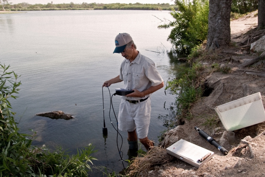 twf-faq-protect-sources-from-pollution-runoff-water-testing-lower-rio-grande-valley Man with glasses using equipment to monitor water quality of river