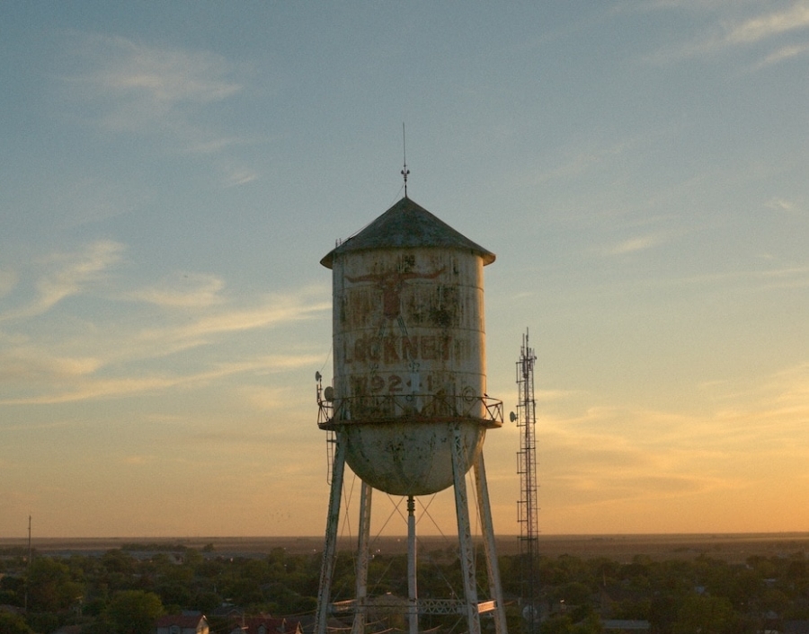Old water tower against sunset sky in a rural landscape